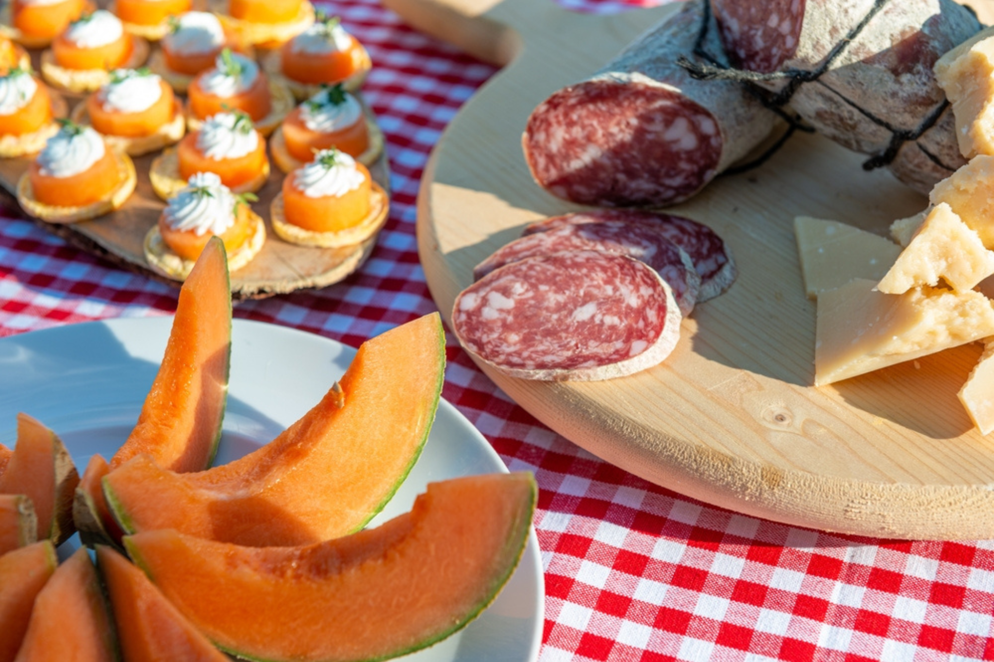 Melone e Salumi Buffet Apparecchiato su Tovaglia a Quadretti